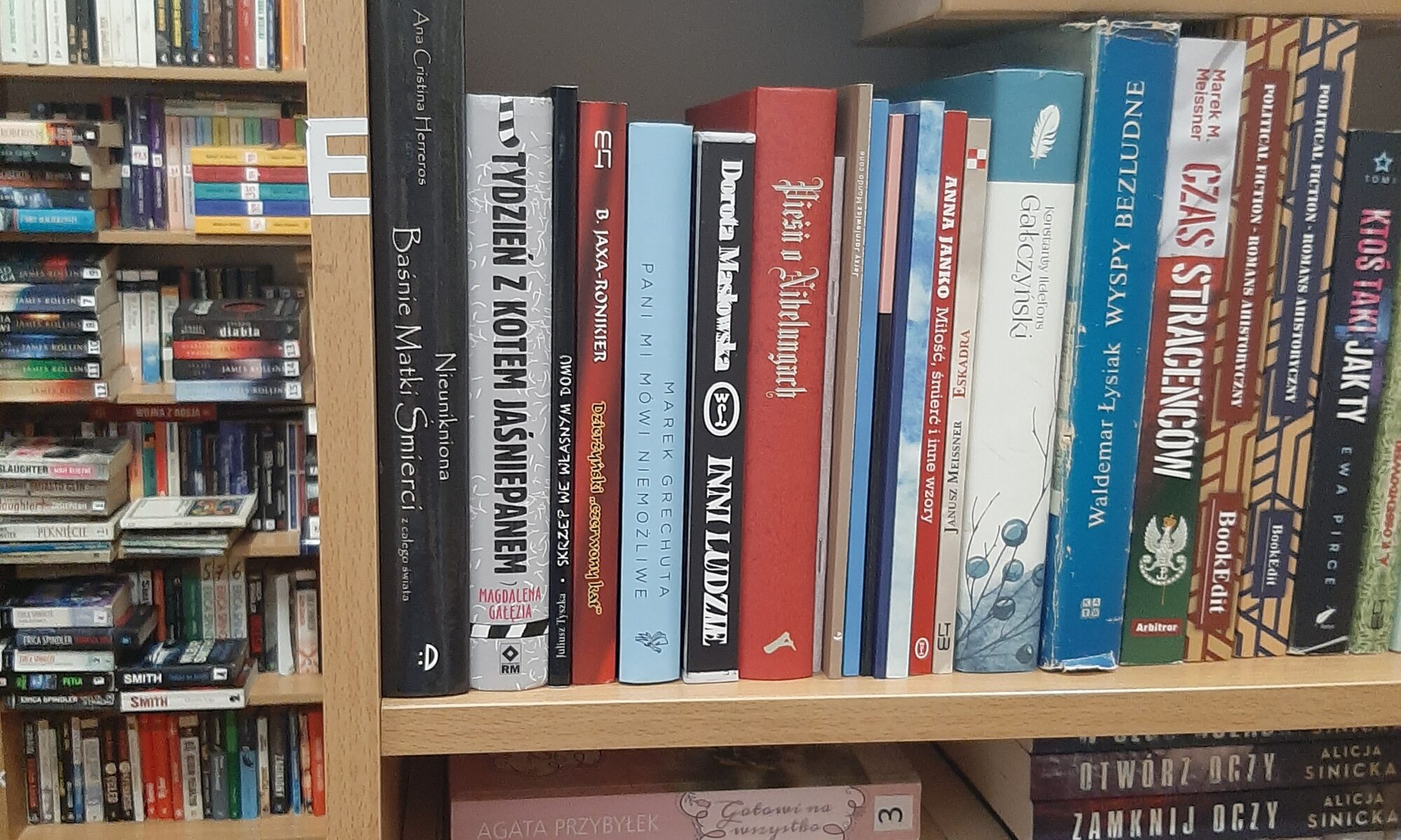 zdjęcie przedstawia książki na półkach szafek bibliotecznych, różnokolorowe grzbiety okładek ustawionych w pionie